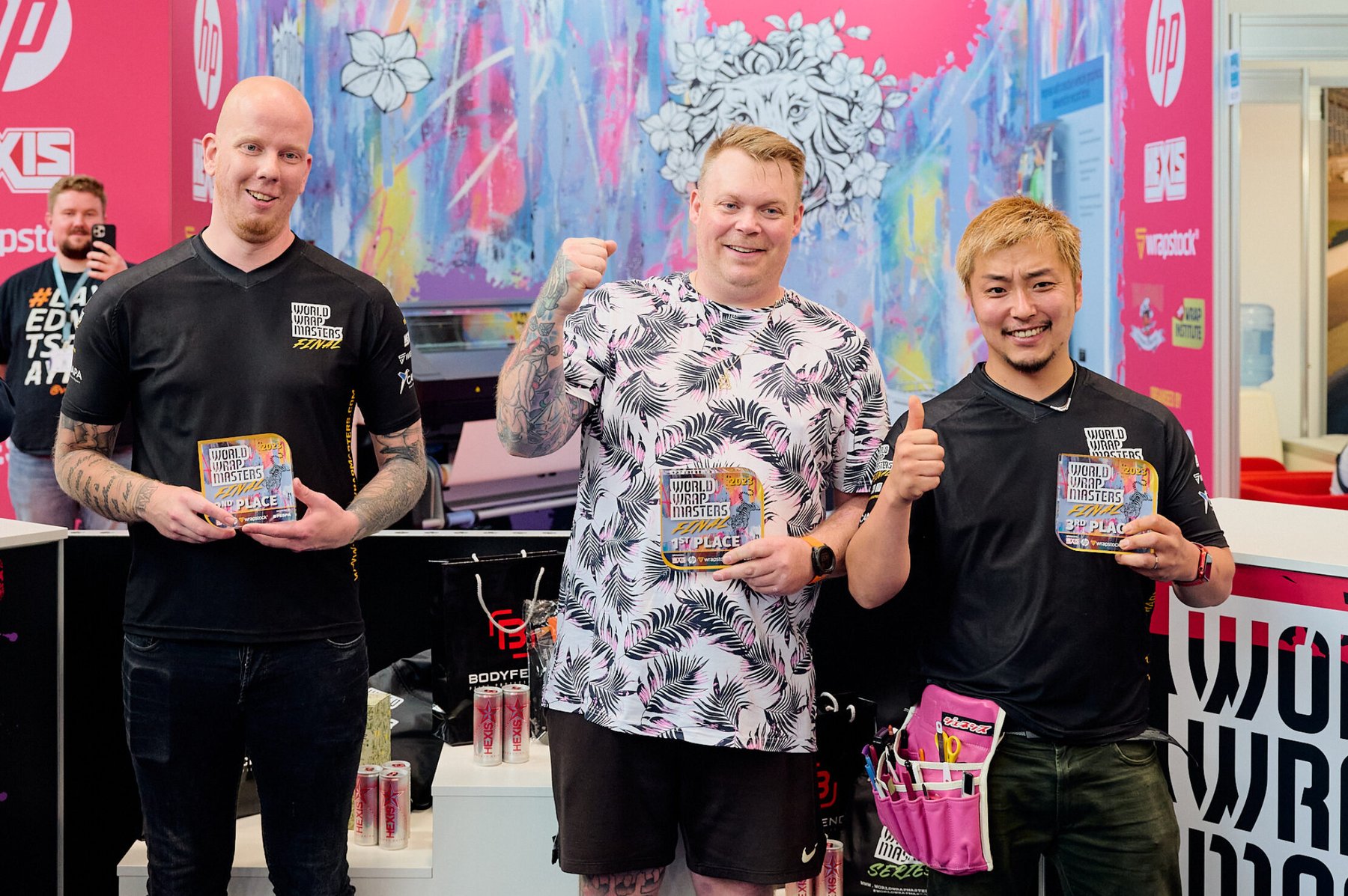 Three smiling winners of the World Wrap Masters Final holding their 1st, 2nd, and 3rd place awards.