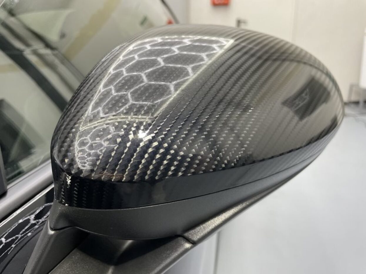 Car side mirror wrapped in high-quality, glossy carbon fibre film.