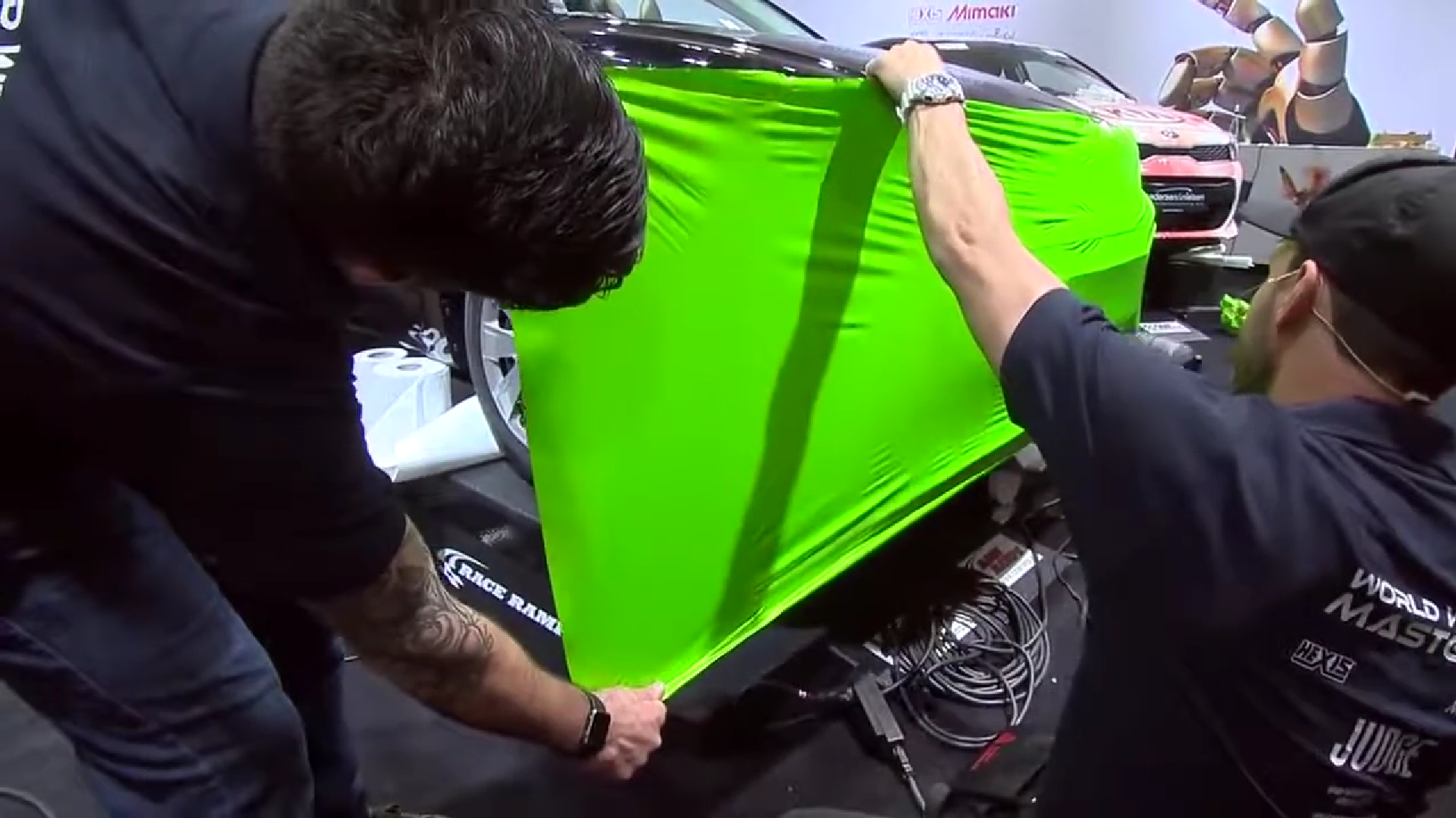 Justin Pate from the Wrap Institute shows a technique for new installers on how to pull the material to get it correctly onto a car. How hard do you pull the film? What direction do you pull the film? Justin and Kiss show new installers how to wrap a car's bumper and how to create 