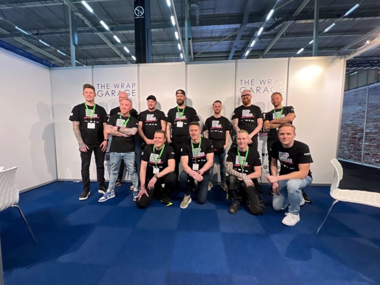 Eleven members of The Wrap Garage team posing at the FESPA Wrap Masters competition stand.