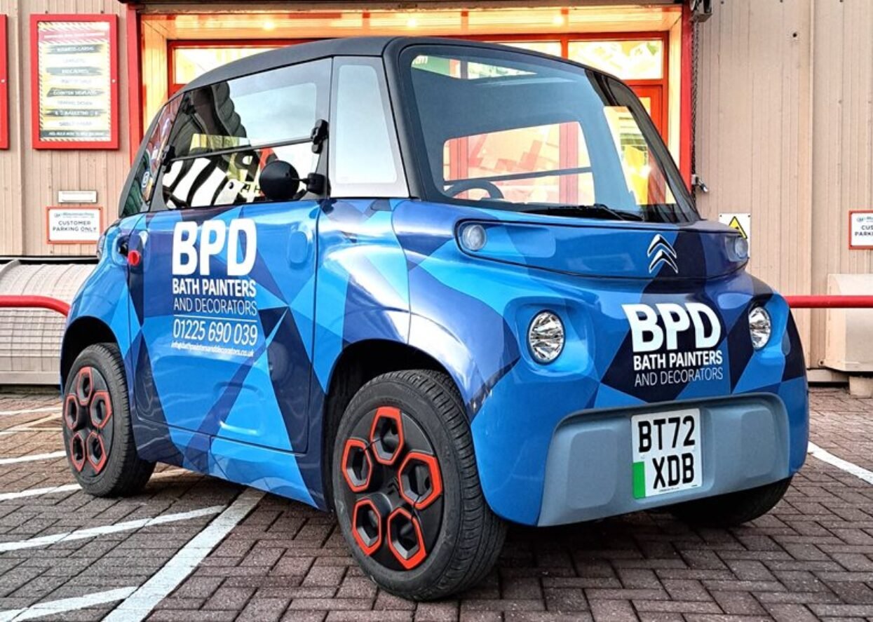 A Citroen Ami electric vehicle wrapped in a blue geometric design for BPD Bath Painters and Decorators.