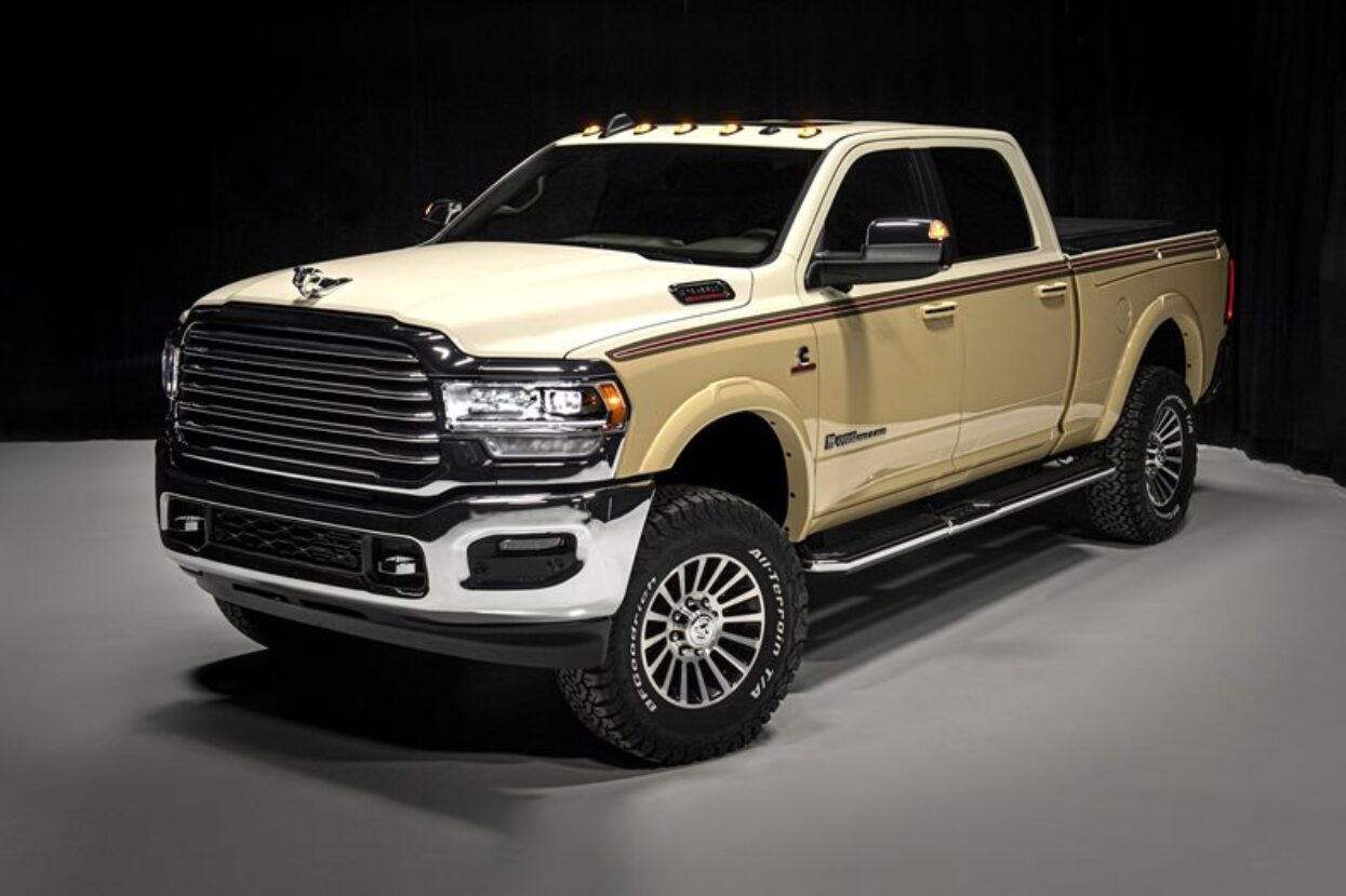 Custom wrapped cream pickup truck featuring red and black pinstripes and large off-road tyres.
