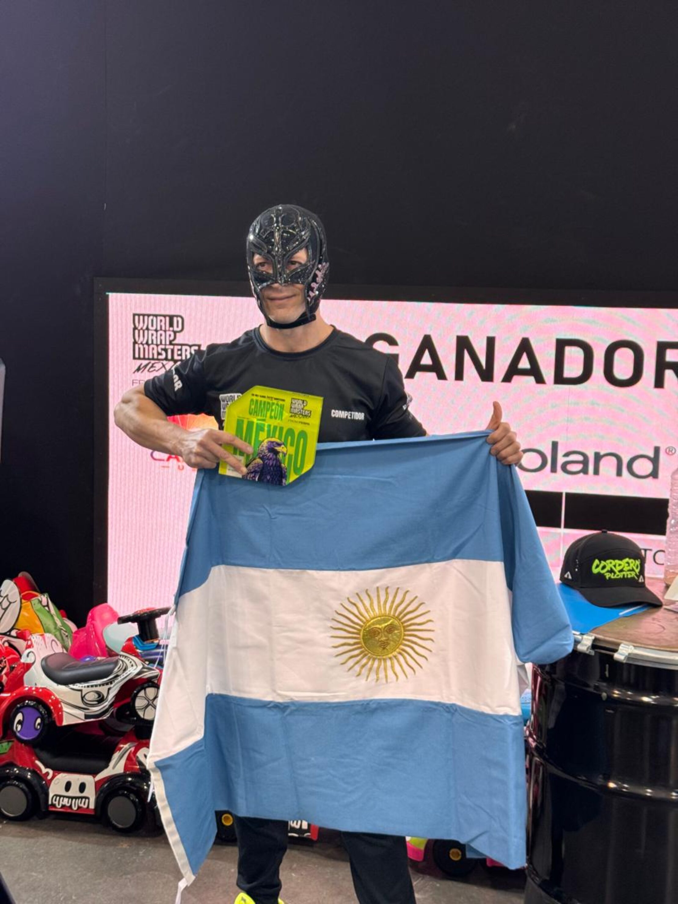 Damian Cordero - Masked winner of the Wrap Masters competition holds the Argentinian flag and a 'Campeon' award.